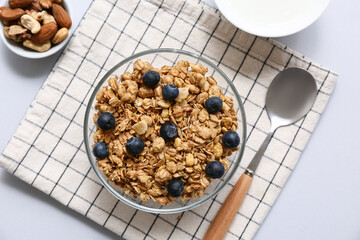 Napkin, bowl with tasty granola and blueberries on grey background, closeup