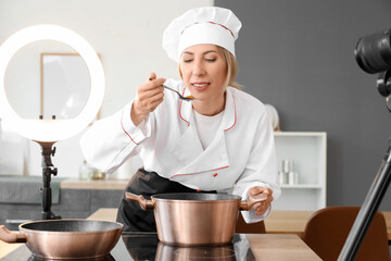 Female food blogger cooking soup while recording video in kitchen