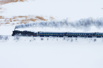 Retro steam train moves at winter morning time