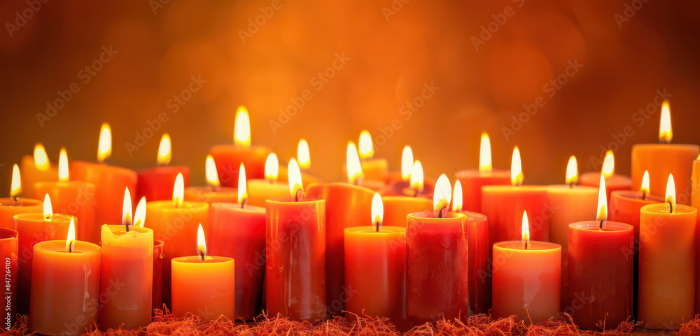 Wall mural rows of candles with flames burning against an orange background, creating a warm and vibrant ambian