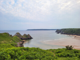 Three Cliffs Bay in South Gower. A long sandy beach with three limestone cliffs with very high and strong tides.
