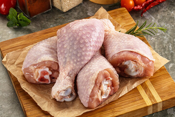 Raw uncooked chicken drumsticks over board