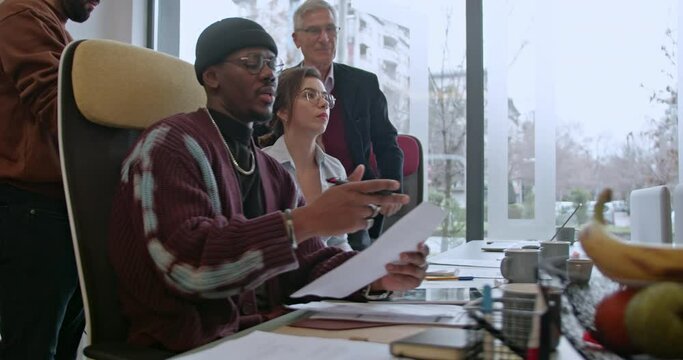 In a well-lit office space, creative businesspeople are busy collaborating on a new project, exemplifying teamwork and dedication to their work.