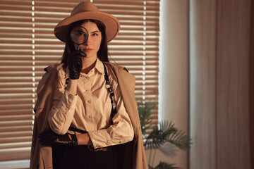 Female spy with magnifier in office at night
