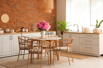 Vase with peonies flowers on dining table in kitchen