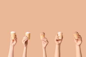 Female hands with different sweet ice-cream in waffle cups on brown background