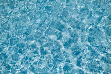 background of blue water swimming pool surface in sun light