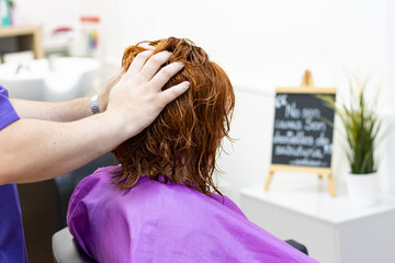 The lady receiving hair treatment at a beauty salon from a hairdresser.