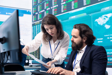 Company employees exchanging project details and big data to help in achieving business objectives, establishing budget and resources. Management team sharing information.