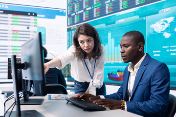 Business associates evaluating key performance indicators within the company, conducting...