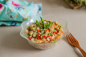 Fresh summer quinoa salad on glass bowl with wooden fork
