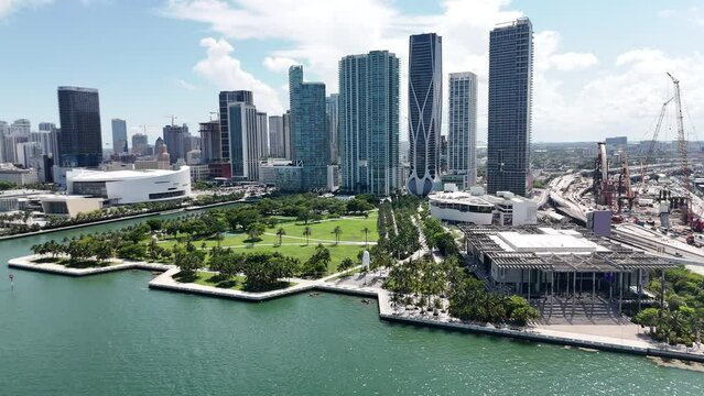 epic wide shot of downtown miami from a drone showing a park, buildings, museums, and arena in south florida during sunny day