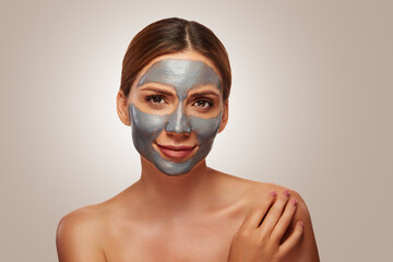 Beautiful young woman with facial mask and bare shoulders
