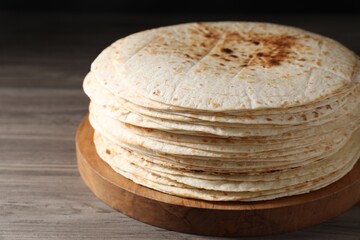Many tasty homemade tortillas on wooden table