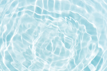 Blue water with ripples on the surface. Defocus blurred transparent blue colored clear calm water surface texture with splashes and bubbles. Water waves with shining pattern texture background.