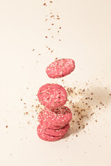 Pink cookies fall on a base with flax and sesame seeds. Concept of diet light food. Sugar free