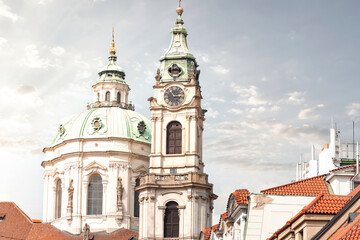 Obraz premium St. Nicholas Church tower and dome rising above Prague rooftops. Czech Republic