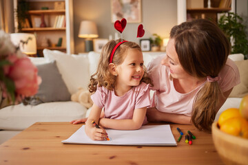 Mother and daughter drawing together at home