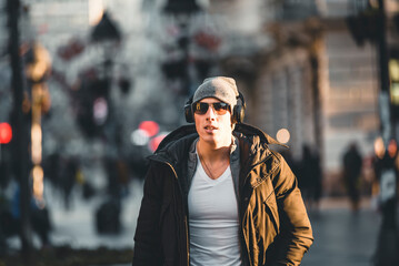 Young Man in the Winter City Streets with Headphones