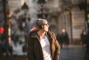 Fototapeta premium Young Man in the Winter City Streets with Headphones