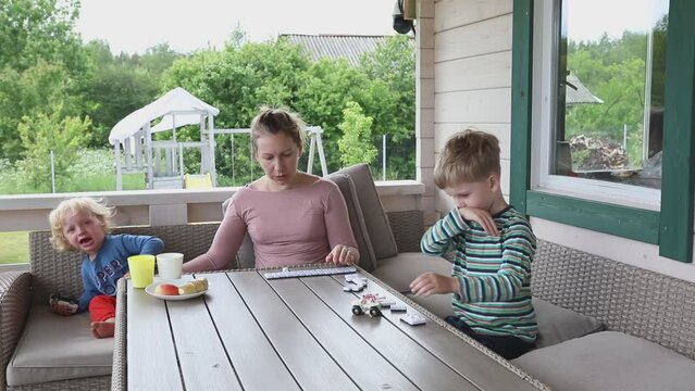 Mother and Sons Play Dominoes on Terrace Summer Day