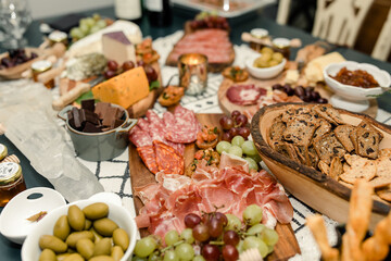 Close-up of a lavish charcuterie board with meats, cheeses, olives, and grapes