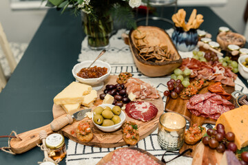 Assorted charcuterie board with meats, cheeses, olives, and grapes