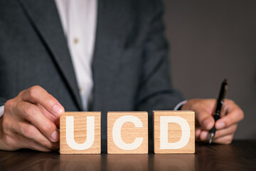 There is wood cube with the word UCD. It is an abbreviation for User Centered Design as...