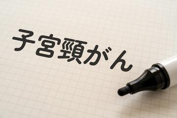 子宮頸がんと書かれたノートとマーカー