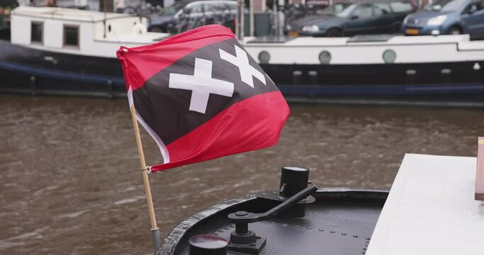 Amsterdam flag with three big X signs waving in the wind.