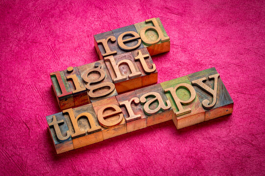 red light therapy - text in vontage letteprress wood type against textured art paper, health and self care concept