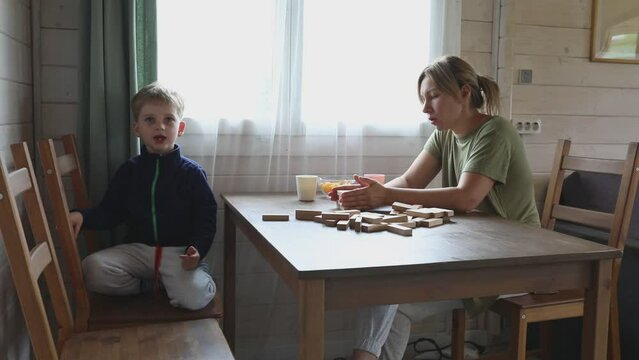 Mother and Son Play Jenga Game Together in Home