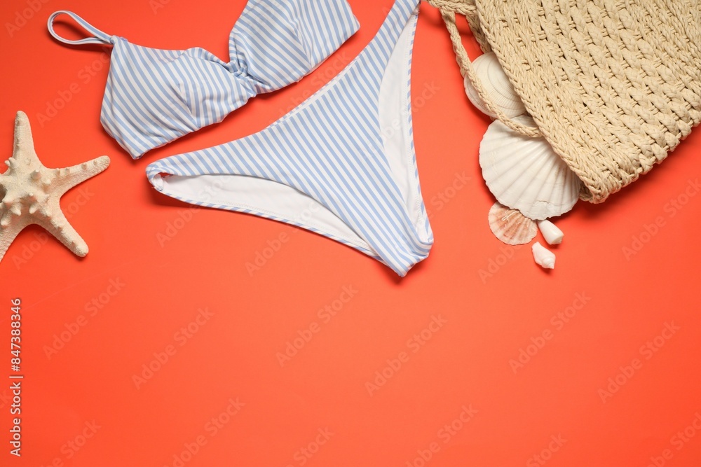 Canvas Prints Striped swimsuit, bag, seashells and starfish on coral background, flat lay. Space for text