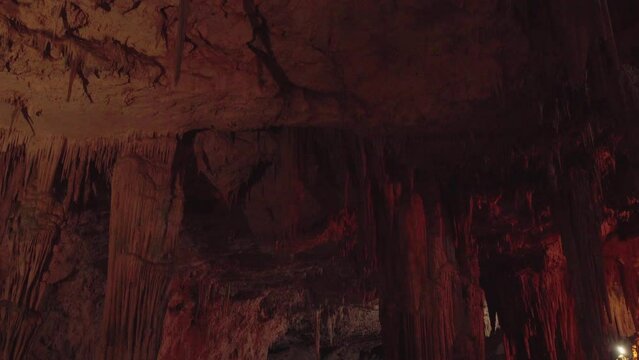 Alghero , Italy - 1 may 2024 Tourists visiting the Neptune Grotto touring a cavern full of stalactites.