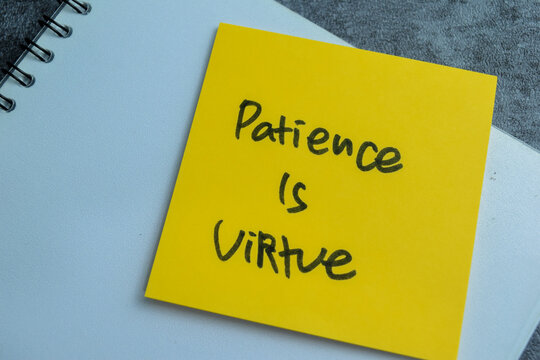Concept of Patience Is Virtue write on sticky notes isolated on Wooden Table.