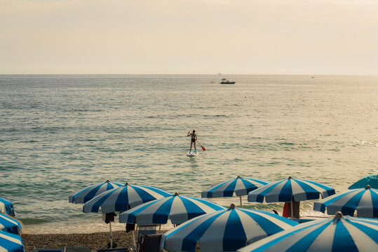 Beach with blue umbrellas on Mediterranean coast 