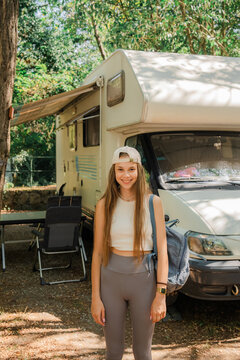 Teenage girl near the camper van in camping during vacation in summer 
