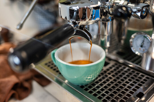 An espresso being made on a stainless steel coffee machine.