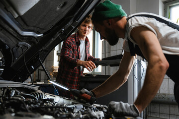 A man uses a laptop working in the garage