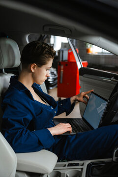 An auto mechanic performs computer diagnostics of a car