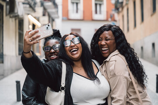 Three happy smiling sisters take a selfie