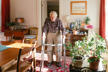 elderly man/ senior citizen walking in his home
