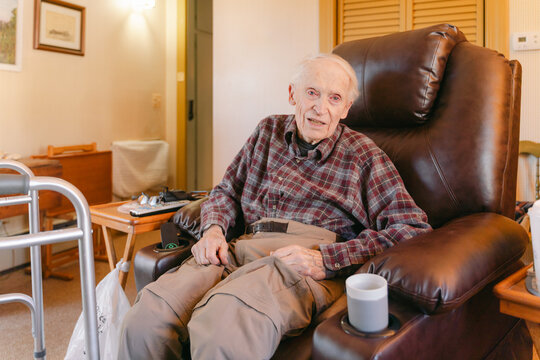 elderly man sitting and chatting in his living room. 