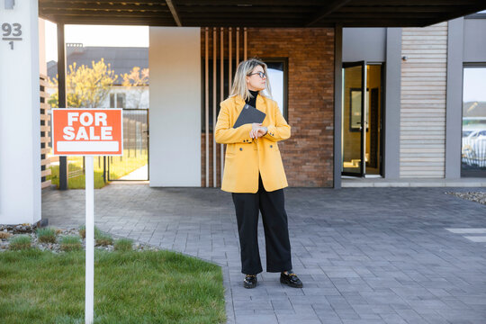 The realtor is waiting for buyers near the house