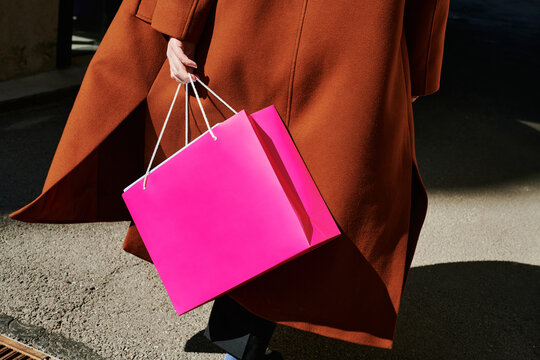 Elegant shopper carrying bright pink bag