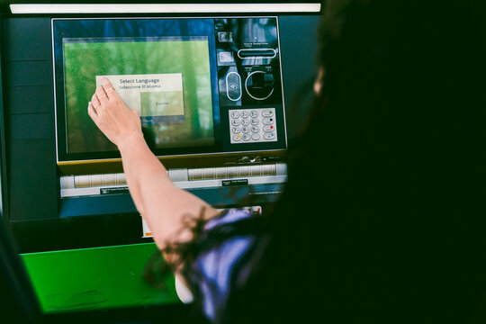 young woman getting cash at drive through ATM