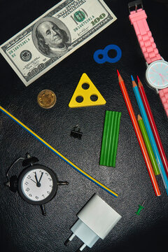 Assortment of everyday objects on dark leather background. 