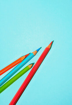 Colorful pencils on a blue background with copy space. 