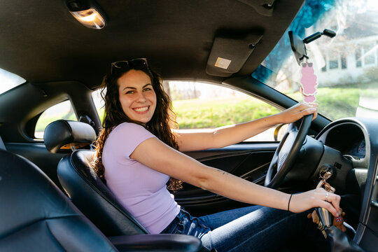 smiling young woman driving her car 
