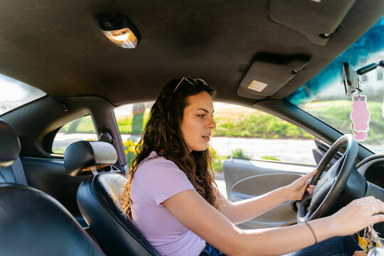 young woman behind steering shell in her car 